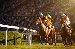 Two-jockeys-during-horse-races-on-his-horses-going-towards-finish-line.---320X208